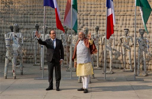 Indian Prime Minister Narendra Modi, right and French President Francois Hollande wave to the media at the Rock Garden in Chandigarh, India, Sunday, Jan. 24, 2016. Hollande began a three-day visit to India on Sunday that could push a multibillion-dollar deal for combat airplanes and closer cooperation on counterterrorism and clean energy. (AP Photo/Manish Swarup)