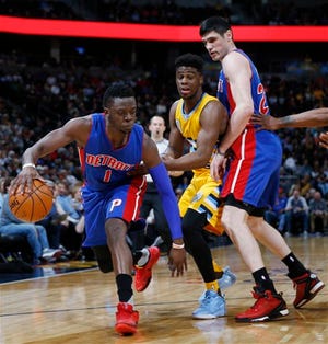 Detroit Pistons guard Reggie Jackson, left, slips past Denver Nuggets guard Emmanuel Mudiay, center, as he gets caught in a pick set by Pistons forward Ersan Ilyasova, of Turkey, in the first half of an NBA basketball game Saturday, Jan. 23, 2016, in Denver. (AP Photo/David Zalubowski)