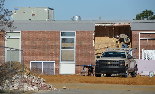 A construction worker stands within a demolished wall at Arendell Parrott Academy in Kinston, where remodeling and expansion work is taking place.
