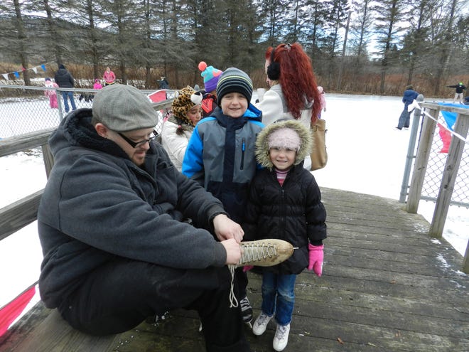 Stefan Baumann of Bloomingburg laces up for a skate Sunday with his niece and nephew, Lila and Cody Hanson, ages 4 and 7. It was their first time at the Livingston Manor Rotary Ice Carnival, now in its 57th year. GITTEL EVANGELIST/TIMES HERALD-RECORD