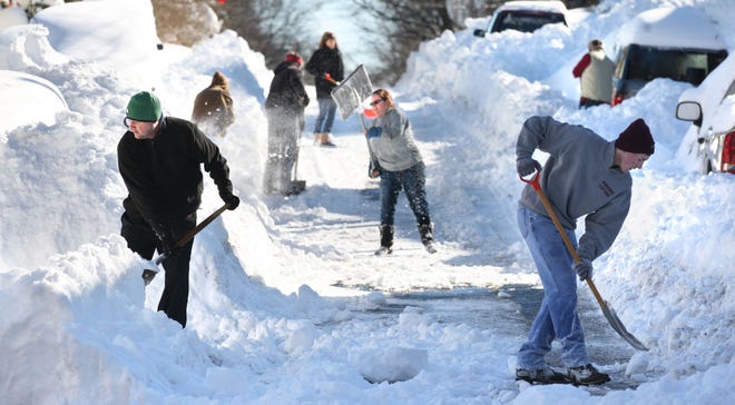 Residents join forces Sunday to shovel out their street after a massive weekend snowstorm dumped more than 30 inches of snow on Winchester, Va., on Friday night and Saturday.