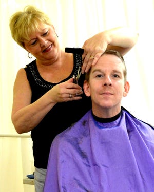 Cinda Lewis gives Peter Pozsqai a haircut during a recent Third Saturday Community Connection. By the end of the day, she gave 27 free haircuts. NEWS-JOURNAL/RIC BUSH