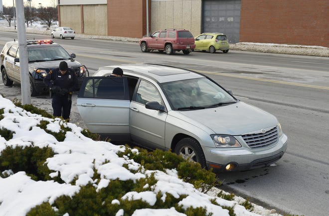 Erie police investigate a Chrysler Pacifica on the 200 block of West 12th Street as part of a robbery investigation on Jan. 24 in Erie. Police said a vehicle matching its description was involved in an armed robbery reported at West Front and Liberty streets earlier in the day. The vehicle was discovered on West 12th Street and towed from the scene. ANDY COLWELL/