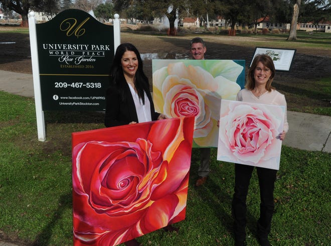Artist Erin Elizabeth, left, Kevin and Sandy Huber, hold the Rose painting in front of area where University Park World Peace Rose Garden will be located at Magnolia and California Streets. CALIXTRO ROMIAS/THE RECORD
