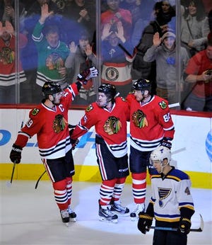Chicago Blackhawks' Andrew Shaw (65) celebrates with teammates Jonathan Toews (19) and Marian Hossa (81), of Slovakia, after scoring a goal during the third period of a hockey game against the St. Louis Blues Sunday, Jan. 24, 2016, in Chicago. Chicago won 2-0. (AP Photo/Paul Beaty)