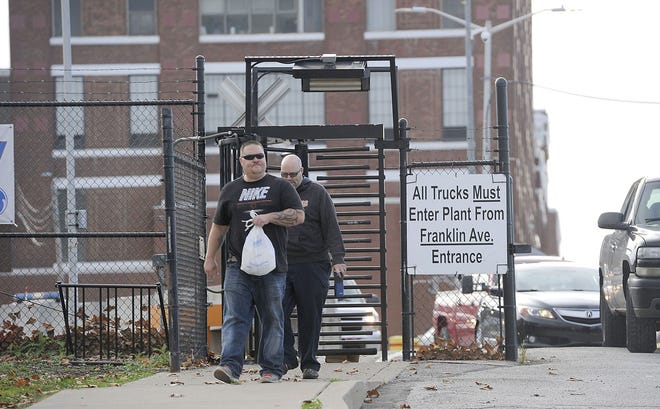 On Nov. 6, Brad Kopp, foreground, and Mike Anderson, background, leave the GE Transportation manufacturing plant in Lawrence Park Township through the Water Street gate at the conclusion of their work shifts. Earlier in the day, officials from the plant announced the layoff of 1,500 hourly workers at the plant. CHRISTOPHER MILLETTE/