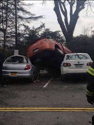 No one was injured when the top car ended up on top of two others in a parking lot in the town of Ulster, according to town police.