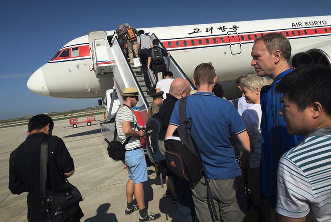 FILE - In this June 27, 2015, file photo, passengers board an Air Koryo plane bound for Beijing, at the Pyongyang International Airport in Pyongyang, North Korea. Without banning it outright, the U.S. State Department has long warned against travel to North Korea. But, post purported H-bomb test, the U.S. is now reportedly seeking a ban on tourism and restrictions to keep the North's flagship airline, Air Koryo, from flying into and out of airports abroad. Most tourists board their flights to Pyongyang from Beijing. (AP Photo/Wong Maye-E, File)
