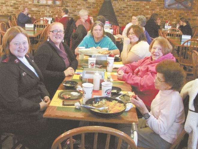 Lt. Sarah Eddy, far left, eats with some members of the community at Monical’s Pizza on Wednesday afternoon.