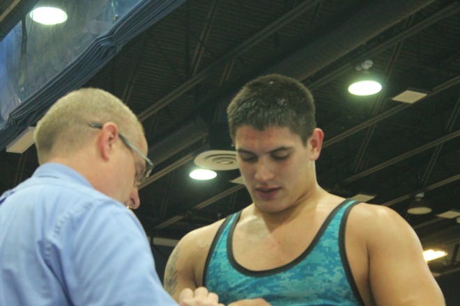 Jordin Castanheira of Matanzas checks his head gear with coach John White during a match earlier this season. Castanheira turned in a strong performance at the Nathan Brouwer duals with four wins by pin. NEWS-TRIBUNE/ANDY MIKULA