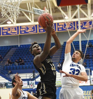 Jalen Redmond puts up a fast break layup over Dru Dawson during a basketball game between the Choctaw Yellow Jackets and the Midwest City Bombers tuesday night in Choctaw.TYLER DRABEK/For The Oklahoman.