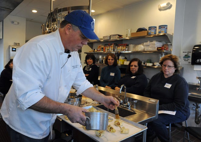 Austin Peters puts the finishing touch on his mini crostatas with carmelized onions, bleu cheese and bacon during one of his regular classes in the new kitchen at the Cultural Center of Cape Cod. MERRILY CASSIDY/CAPE COD TIMES