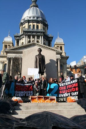 Caprice Sweatt, center, founder and CEO of Medical Cannabis Outreach, speaks during an “Approve the 8” rally on the steps of the Illinois Capitol on Wednesday. Participants hope to see eight more conditions added to the list of state-approved illnesses under the Illinois medical marijuana pilot program.