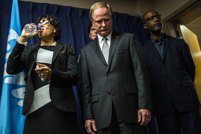 Flint Mayor Karen Weaver drinks from a bottle of water beside Michigan Department of Environmental Quality Director Keith Creagh as Gov. Rick Snyder fields questions from reporters about the Flint water crisis during a press conference on Wednesday, Jan. 27, 2016, at City Hall in downtown, Flint, Mich. Environmental and civil rights groups want a federal judge to order the prompt replacement of all lead pipes in Flint's water system to ensure that residents have a safe drinking supply, a demand that Snyder said on Wednesday might be a long-term option but not an immediate one. (Jake May /The Flint Journal-MLive.com via AP) LOCAL TELEVISION OUT; LOCAL INTERNET OUT; MANDATORY CREDIT