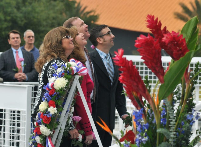 After placing a wreath, daughters and sons of astronauts who have died look up at the names of their loved ones on the Astronaut Memorial during a Day of Remembrance Ceremony on the 30th anniversary of the 1986 space shuttle Challenger tragedy, at the Kennedy Space Center Visitor Complex on Thursday, Jan. 28, 2016. From foreground are Sheryl Chaffee, daughter of Apollo 1 astronaut Roger Chaffee who died in the Apollo 1 fire on Jan. 27, 1967; Kathie Scobee Fulgham and Air Force Maj. Gen. Richard Scobee, children of Challenger commander Dick Scobee who died on Jan. 28, 1986; and Scott McAuliffe, son of Challenger schoolteacher Christa McAuliffe. (Tim Shortt/Florida Today via AP)