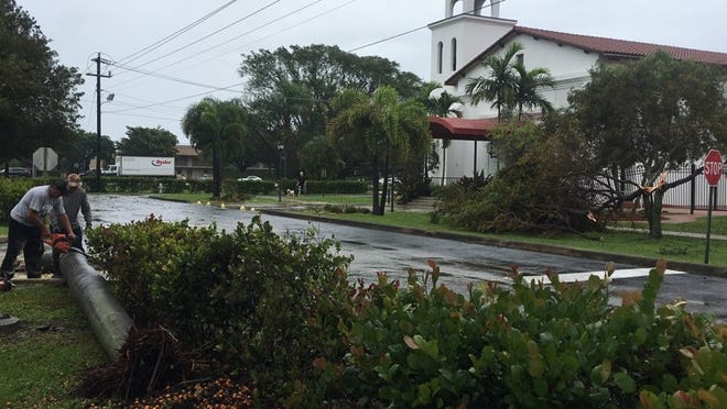 Workers clear debris at St. Mary the Virgin Anglican Church in Delray Beach after a reported tornado in the area.