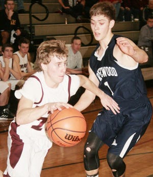 Annawan’s Alex Landwehr, left, drives baseline on Ridgewood defender Jared Smith in LTC tourney action Thursday night. Landwehr scored 20 points and surpassed 1,000 career points in Annawan’s 60-27 win.