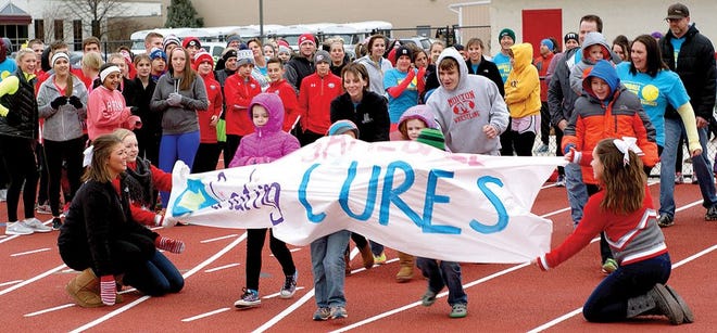 Kids burst through a banner designed by Morton High School students at the fourth annual Gameball Run at Morton High School Thursday. Proceeds raised by the fundraiser go to the Children's Hospital of Illinois.