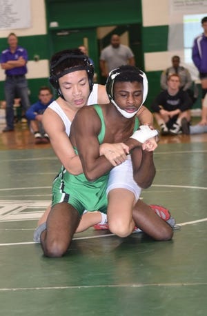 Odevious Otis (right) of Ashbrook wrestlers Adam Nguyen of South Point in the 126-pound finals. Otis won his 100th match of his career and the Green Wave took first place in the Big South conference tourney,