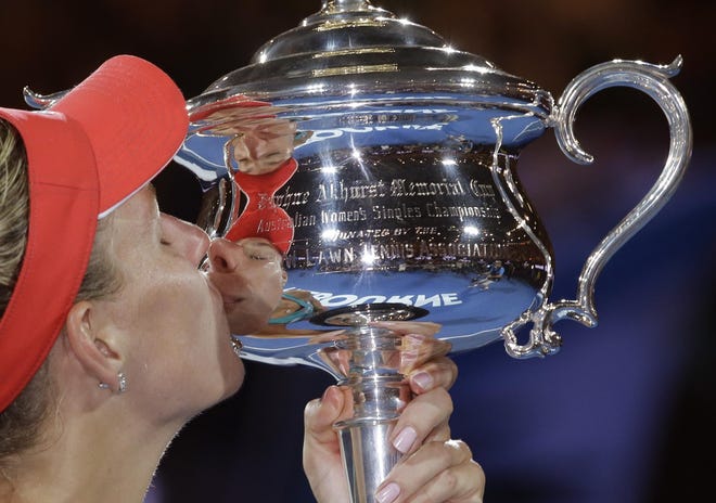 Angelique Kerber of Germany kisses the trophy after defeating Serena Williams of the United States in the women's singles final at the Australian Open tennis championships in Melbourne, Australia, Saturday, Jan. 30, 2016.(AP Photo/Aaron Favila)