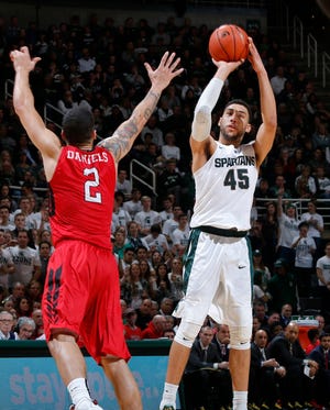 Michigan State's Denzel Valentine (45) shoots against Rutgers' Bishop Daniels (2) during the second half of an NCAA college basketball game, Sunday, Jan. 31, 2016, in East Lansing, Mich. Valentine led Michigan State with 20 points in a 96-62 win. (AP Photo/Al Goldis)
