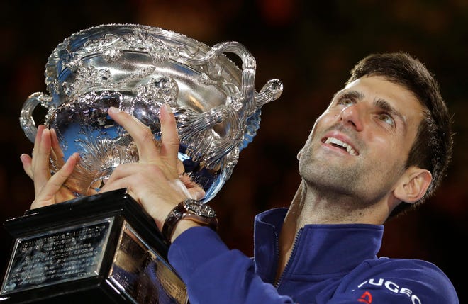 Novak Djokovic holds the trophy after defeating Andy Murray in the men's final at the Australian Open. The Associated Press