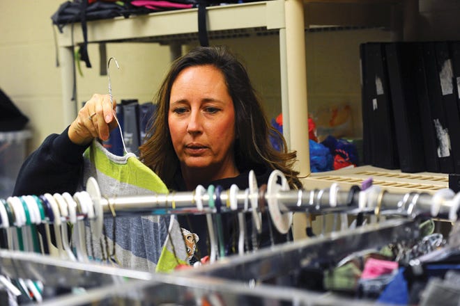 Moms Who Care operator Micki Slaven looks through clothing in the store at Broadmoor Junior High School. All of the items in the store are free to children who otherwise could not afford to buy basic hygiene products, clothing, shoes, school supplies and other necessities.