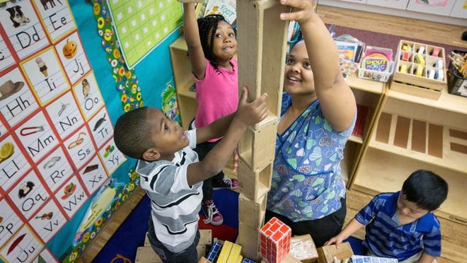 Thelma Pittman Daycare students (to r) Durrell Moore, Diamonique Worthen and Christopher Gomez, help teacher Sandra DeAllie build with blocks in Jupiter, Florida on February 1, 2016. The daycare has been in business for 50 years. (Allen Eyestone / The Palm Beach Post)