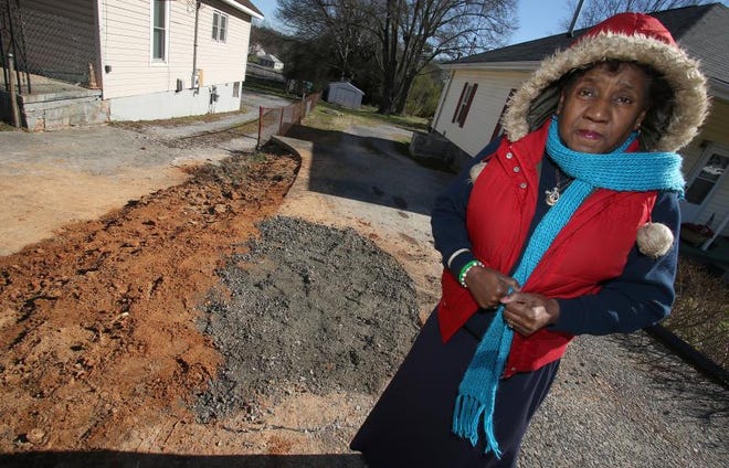 (Photo Mike Hensdill/The Gaston Gazette ) Elder Gretta Youngblood stands next to a filled in sink hole that opened up Monday afternoon under her driveway. The hole was filled in Tuesday morning, January 19, 2016.