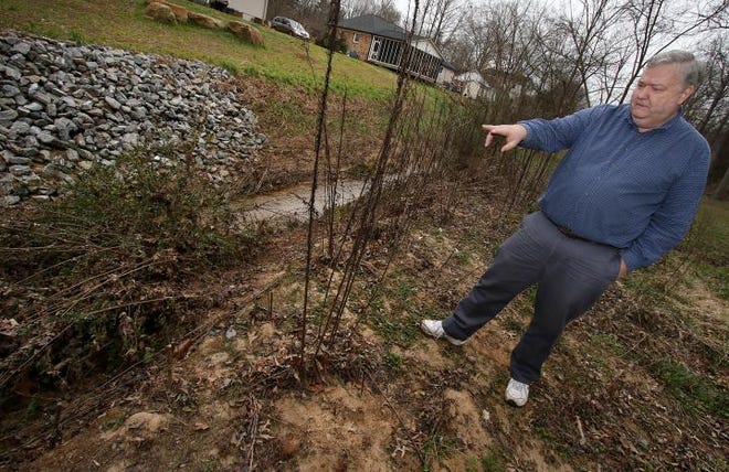 (Photo Mike Hensdill/The Gaston Gazette ) Gardner Park residents are opposed to construction of the new retail center in "Franklin Woods". Here, resident Eric Elliott talks about the negative impact the retail center would have on Duharts Creek and the surrounding area as he walks behind his property on Deerwood Drive Tuesday afternoon, February 2, 2016.