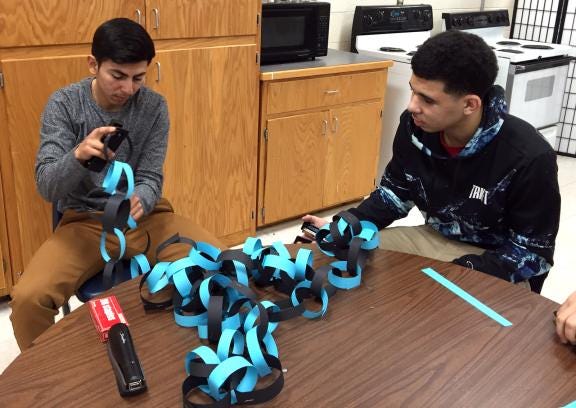 Seniors Adrian Garcia and Markyce Glover work on a Panthers-themed paper chain during foods class at Burns High School on Tuesday. Students in Danna Floyd's foods classes created and hung the decorations throughout the school as part of their "Soup-er Bowl" service project to go along with Friday's Panther Pride Day. (Elise Franco/The Star)
