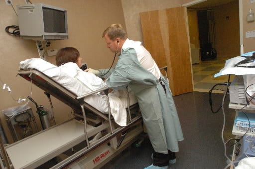 A doctor looks over a patient before an endoscopy procedure.