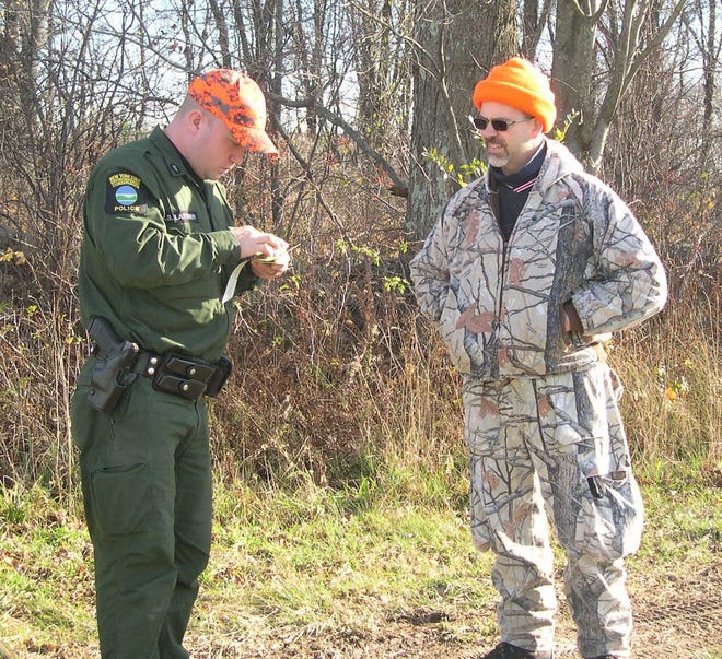 Department of Environmental Conservation Officer Christopher Lattimer, left, talks with hunter Matthew Mabee on opening day of the 2015 hunting season in a field in Greenville. The DEC said the 2015 deer take in the Southern Zone was down 11 percent from a year ago; the 2015 bear take was down 3 percent. TIMES HERALD-RECORD FILE PHOTO