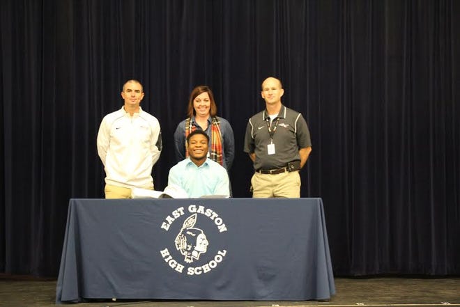East Gaston's Robert Washington (seated in front) with, right to left, Warriors coach Sean Joyce, school principal Cristi Bostic and athletic director Tom Adams
