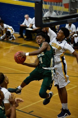 Kinston’s Taji Moore looks for a basket while Goldsboro’s Jalen Thomas defends Tuesday night during the Vikings’ 80-70 victory.