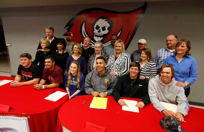 Students from Lubbock-Cooper pose with their parents after signing their letters of intent to play sports in college during National Signing Day on Wednesday, Feb. 3, 2016 at Lubbock-Cooper High School in Woodrow, Texas. (Brad Tollefson/A-J Media)