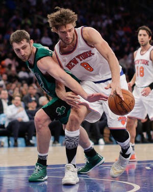 Celtics center Tyler Zeller (44) reaches for a rebound against Knicks center Robin Lopez on Tuesday night. AP Photo