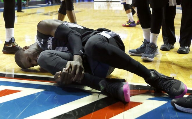 Providence forward Ben Bentil lays on the court in pain after his leg was sandwiched between two DePaul defenders during the first half Tuesday
