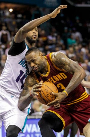 Cleveland Cavaliers forward LeBron James, right, drives into Charlotte Hornets forward Michael Kidd-Gilchrist during the second half of Wednesday's game.