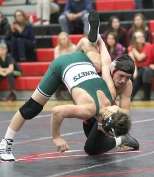 The Chiefs Hunter Rummler works to score back points in his match with Mendon's Jonah Weger. Rummler won with a pin in the first period.