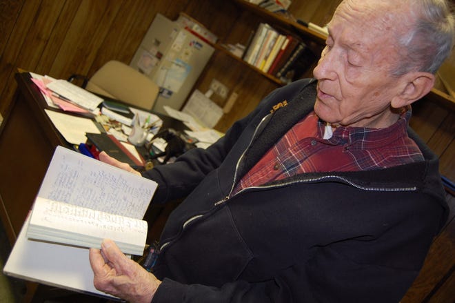 Ernie Ingles looks through a record book of students who signed in for lessons in the mid 1960s. NANCY HASTINGS PHOTO