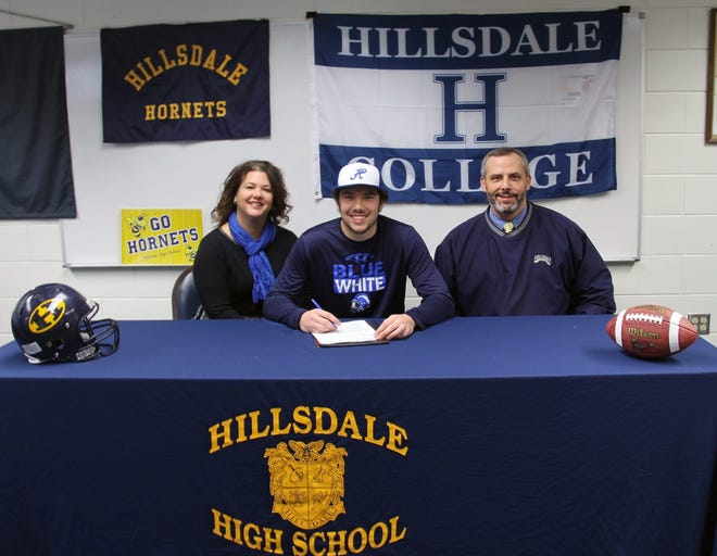 Hillsdale Hornet football standout Martin Petersen (center) signed a letter of intent Wednesday to play football at Hillsdale College. Also pictured are Martin's parents Kathy and Aaron Petersen. MIKE LINVILLE PHOTO