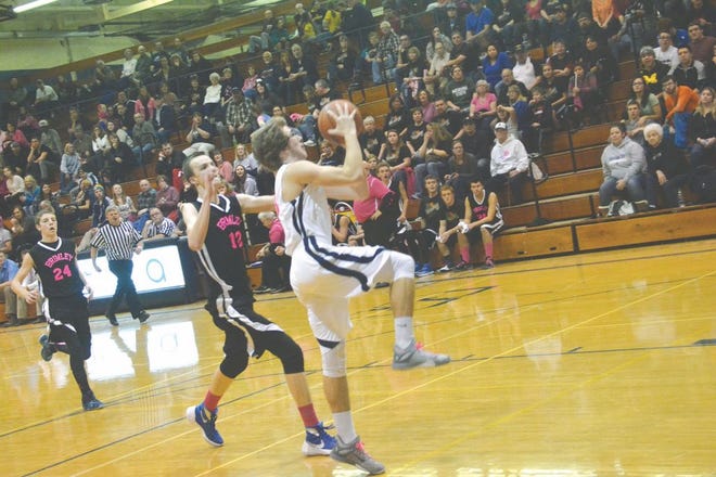 Sault High’s Trevor Bailey drives in for a layup, contested by Brimley’s Jan Brychta in a boys basketball game Tuesday night. The Blue Devils rallied past the Bays 48-45 in the Rivals vs. Cancer fund-raiser game.