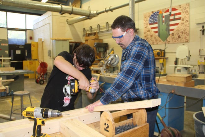 Mike Chuck, a senior at Delaware Valley High School, works with guidance from John Zirpoli, automotive and building construction assistant. Local companies say there are too few young people interested in learning construction skills. JESSICA COHEN/FOR THE GAZETTE