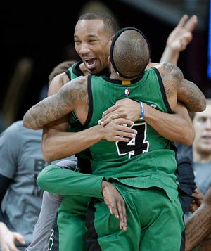 Boston Celtics' Avery Bradley, back, and Isaiah Thomas hug after the Celtics defeated the Cleveland Cavaliers 104-103 in an NBA basketball game Friday, Feb. 5, 2016, in Cleveland. Bradley made a corner jumper at the horn to give the Celtics the win. (AP Photo/Tony Dejak)
