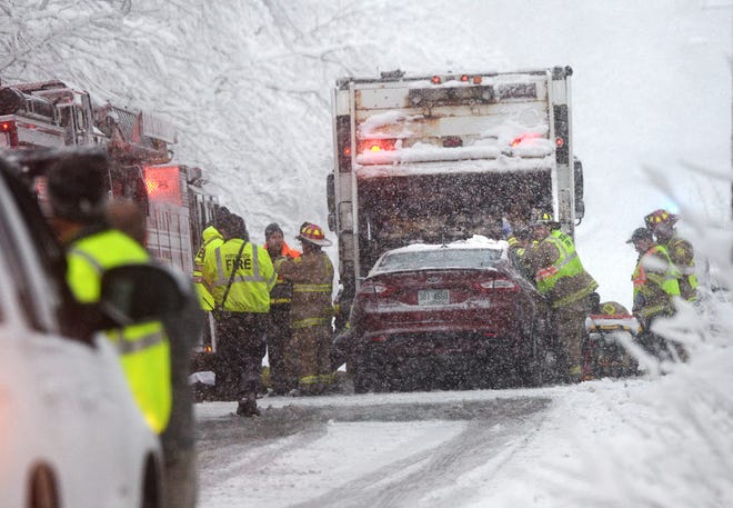 Portsmouth firefighters work at a scene where a car struck a city worker on a garbage truck on Lang Road during a snow storm Friday, according to fire officials.

Deb Cram/Seacoastonline