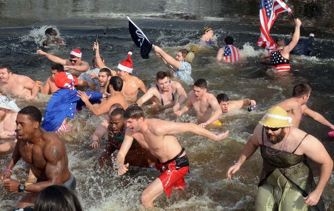 WILLIMANTIC 2-6-2016 Dylan Garrison, at right in dress, and fellow members of the Eastern Connecticut State University rugby team and others run out of the chilling waters of the Natchaug River Saturday during the 5th annual Plunge for Hunger at Lauter Park in Willimantic. See videos and more photos at NorwichBulletin.com John Shishmanian/ NorwichBulletin.com