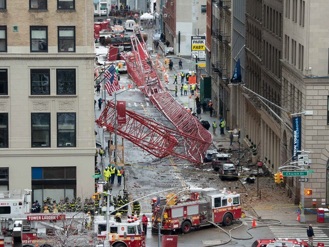 A collapsed crane fills the street on Friday, Feb. 5, 2016, in New York. The huge construction crane was being lowered to safety in a snow squall when plummeted onto the street in the Tribeca neighborhood of lower Manhattan.