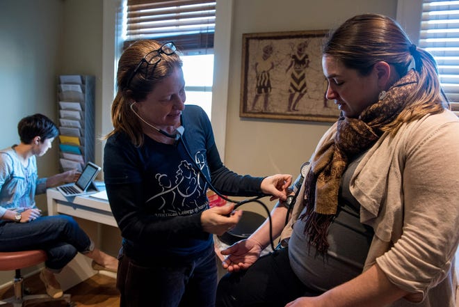 Midwife Whitney Hall takes the blood pressure of pregnant mother Katrina Fernandez of Tivoli, during their appointment at the Hudson Valley Midwifery Center in the City of Kingston on Tuesday. KELLY MARSH/For the Times Herald-Record