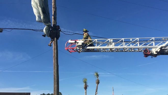 A firefighter works on the rescue of a parachutist Monday morning near DeLand Municipal Airport. Volusia County Professional Firefighters Association